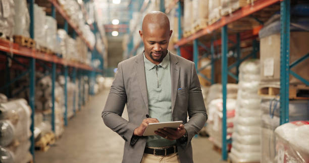 Businessman, logistics and manager with tablet for inventory, stock control or monitoring storage at warehouse. Man, employee or distributor with technology for supply chain or distribution service
